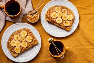 two white plates topped with banana french toast