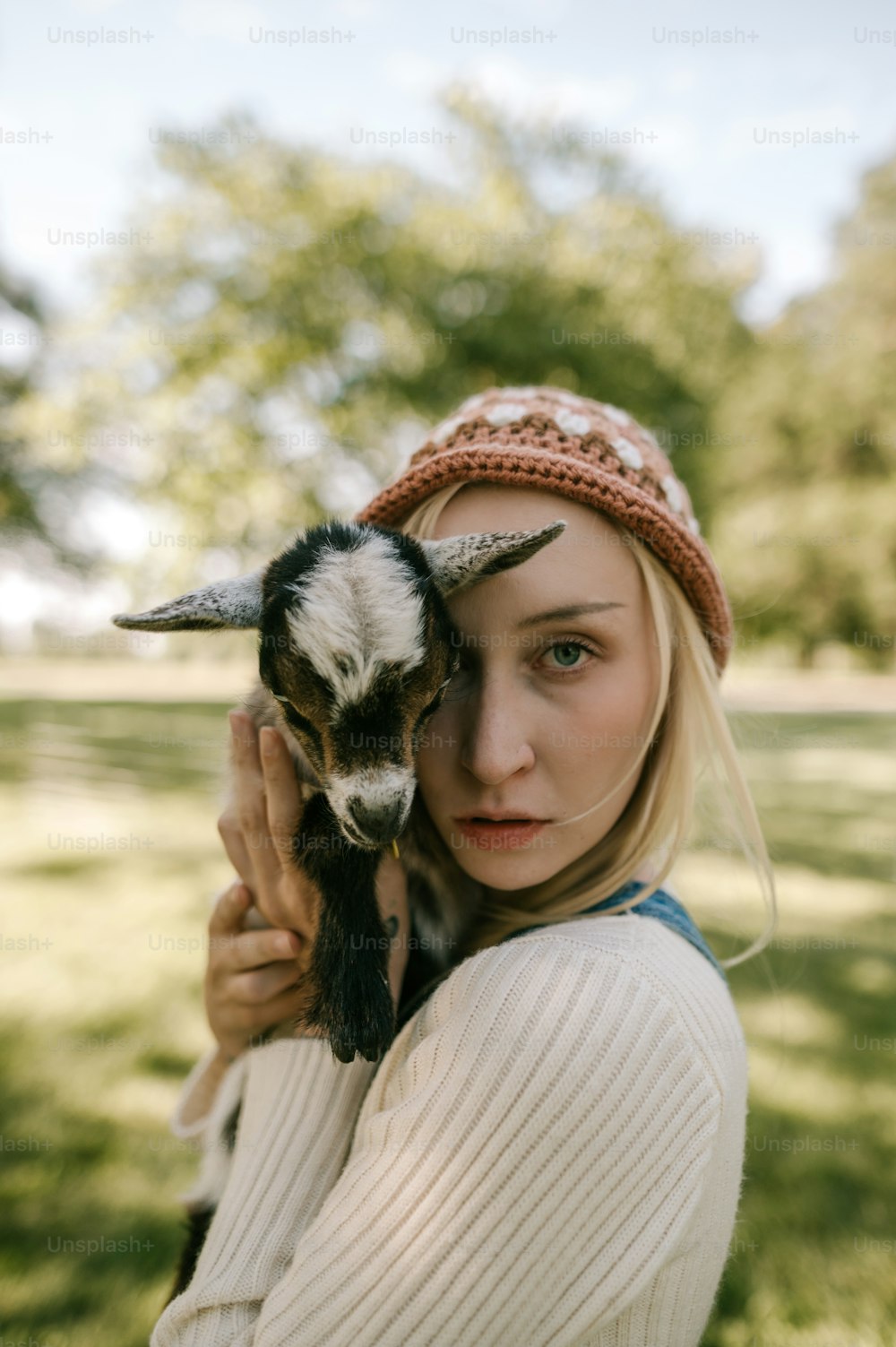 Una mujer sosteniendo una cabra en sus manos
