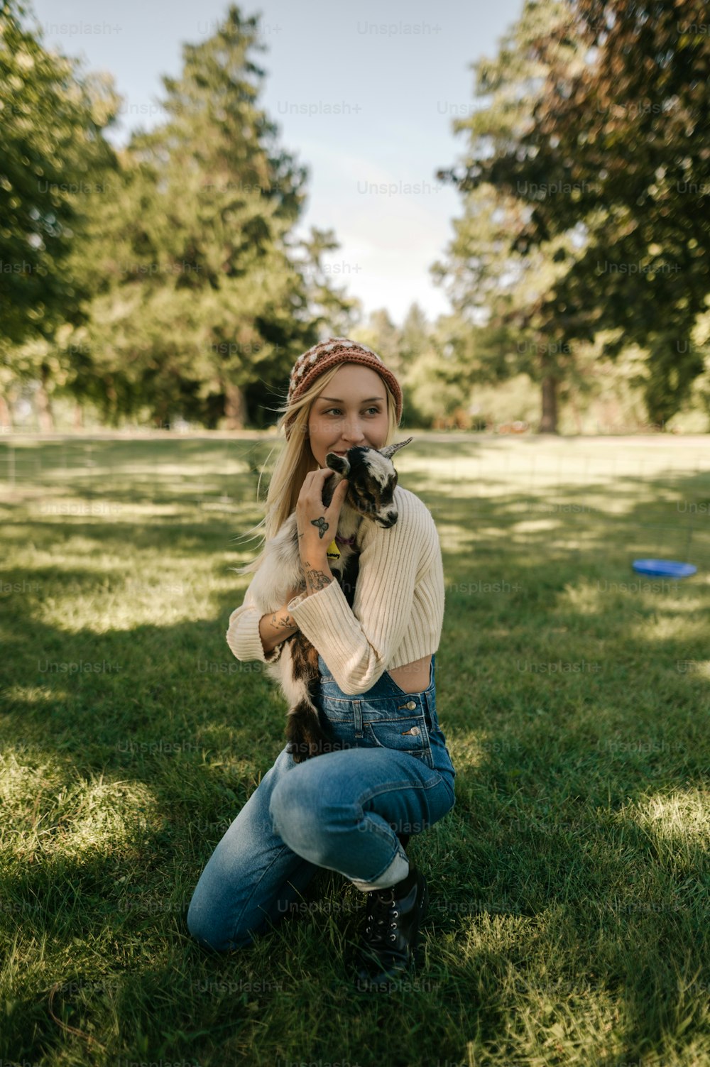 a woman sitting in the grass holding a dog