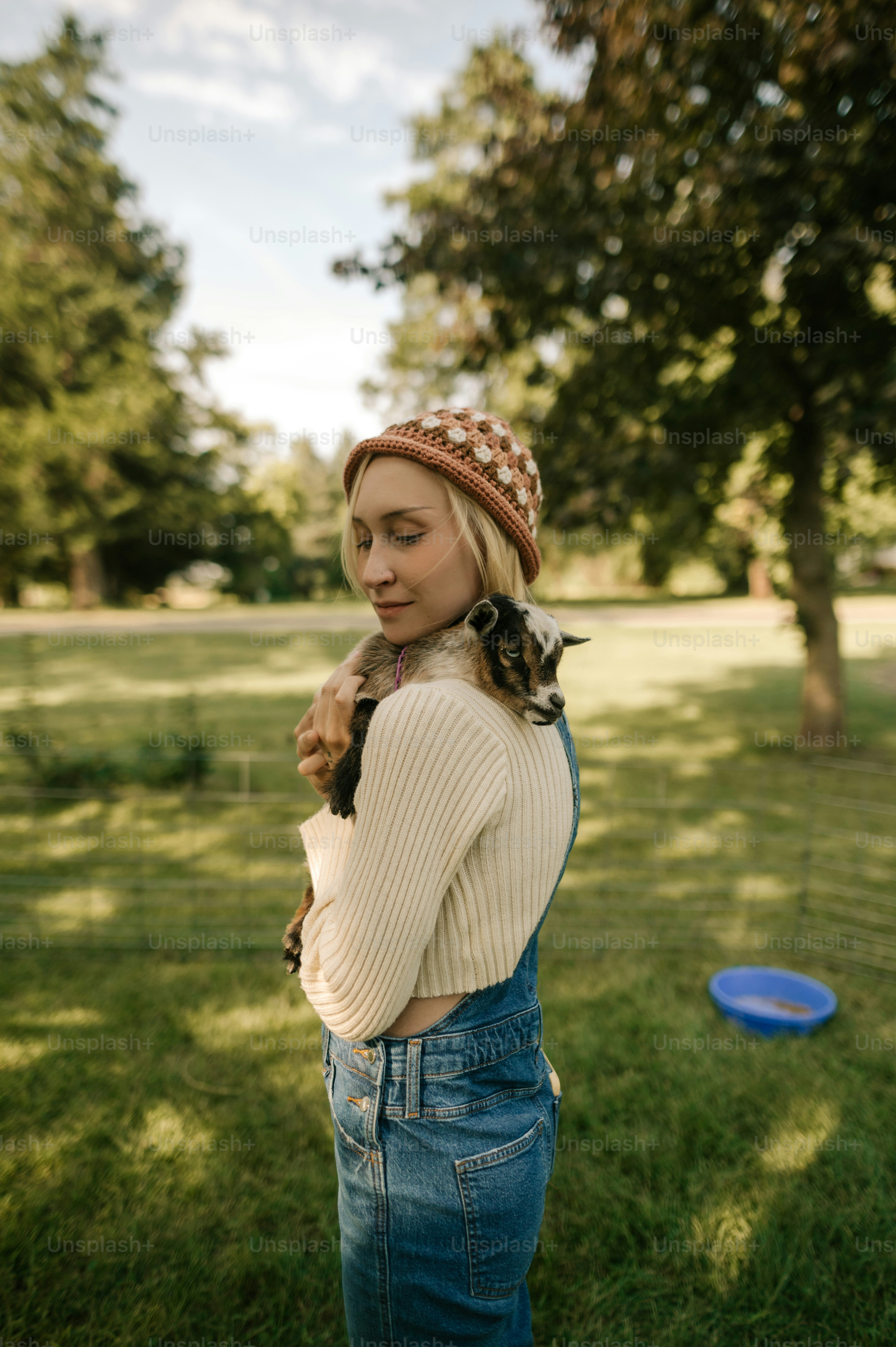 a woman in overalls holding a cat in her arms