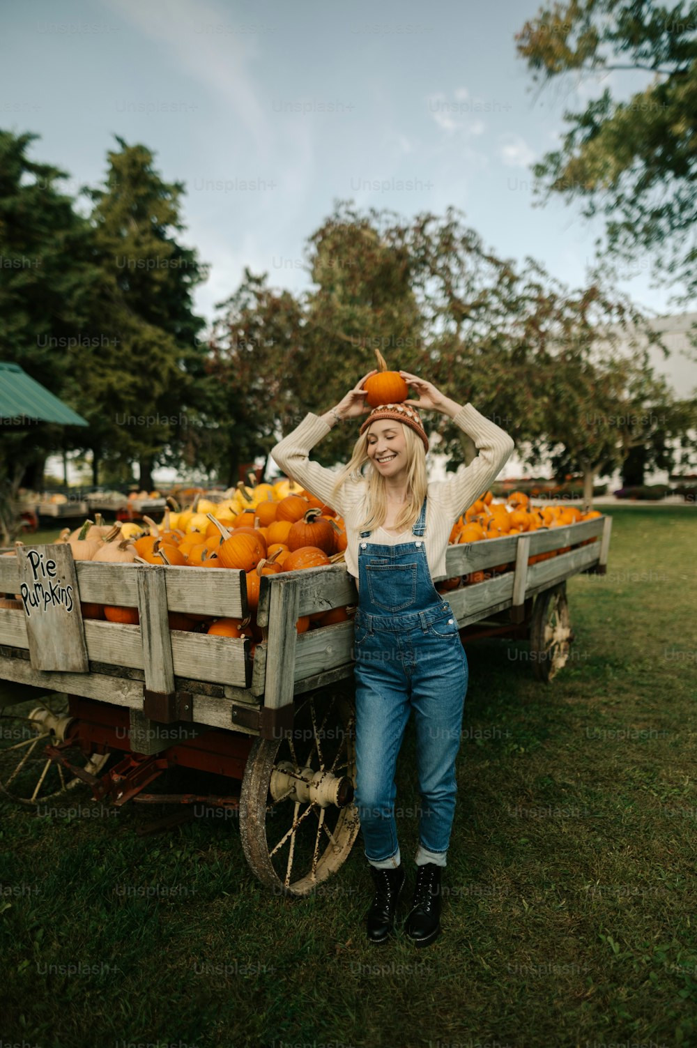 a woman standing next to a wagon filled with oranges