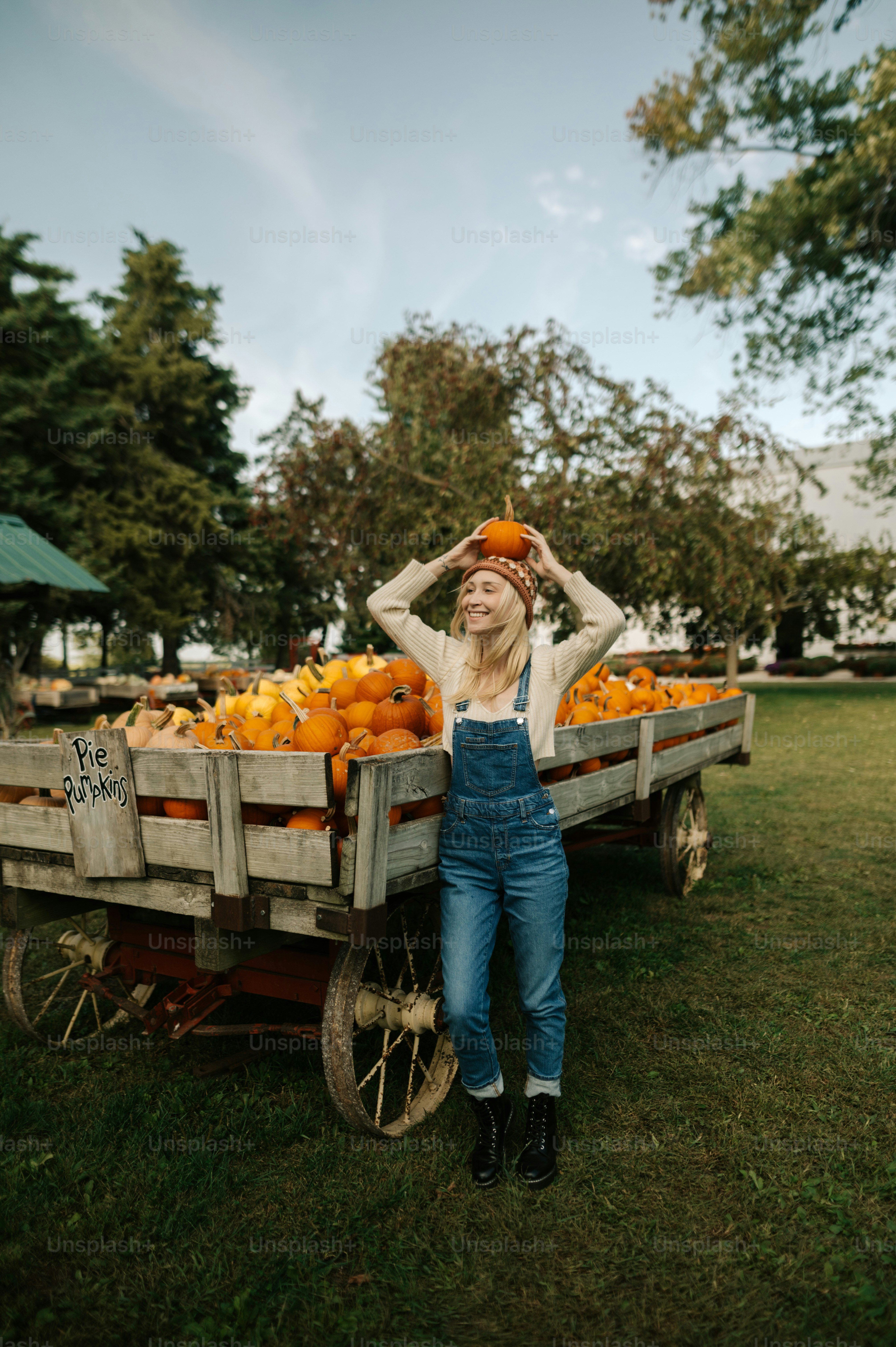 a woman standing next to a wagon filled with oranges