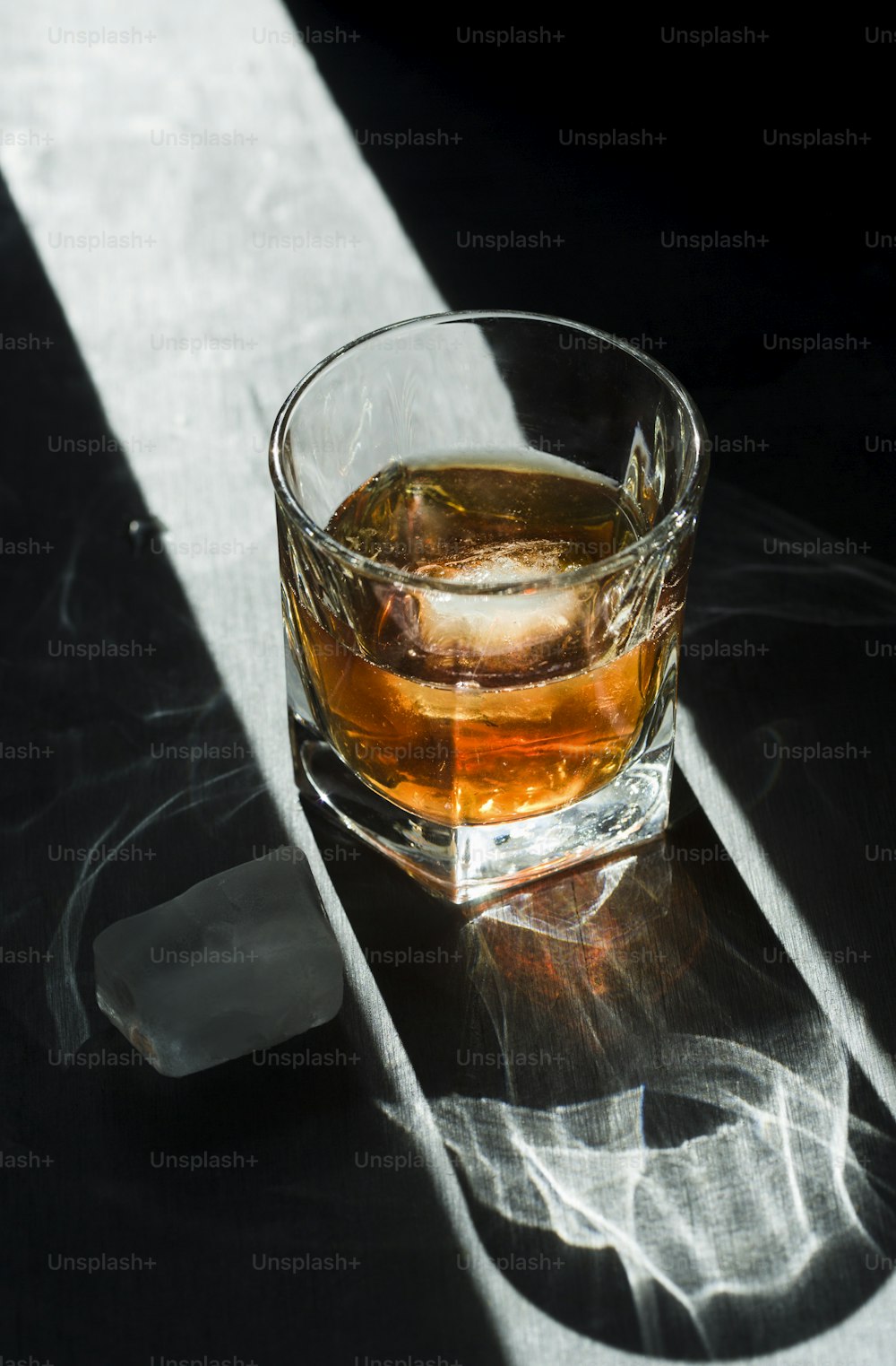 Un vaso de whisky sentado encima de una mesa