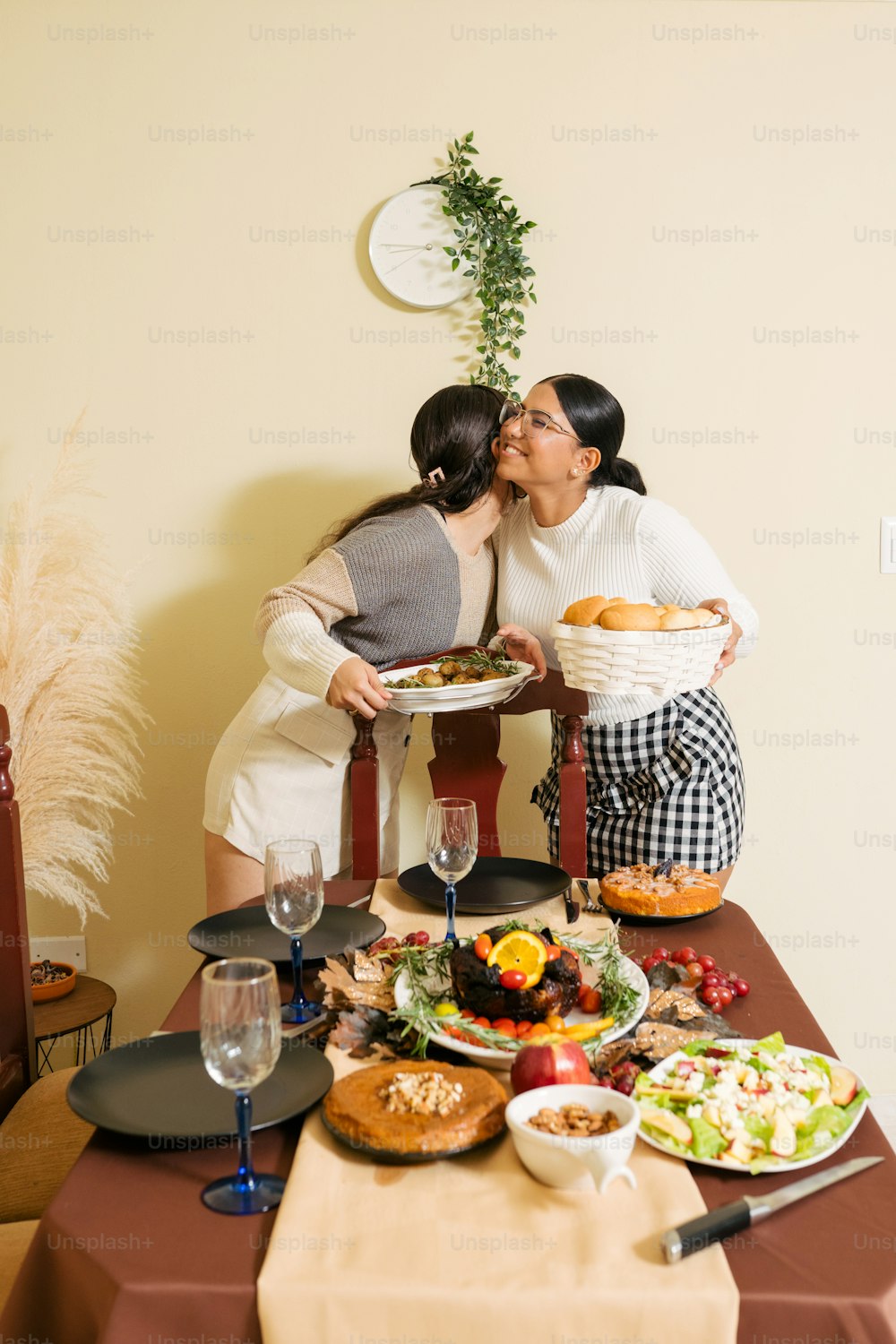 two women kissing each other over a table full of food