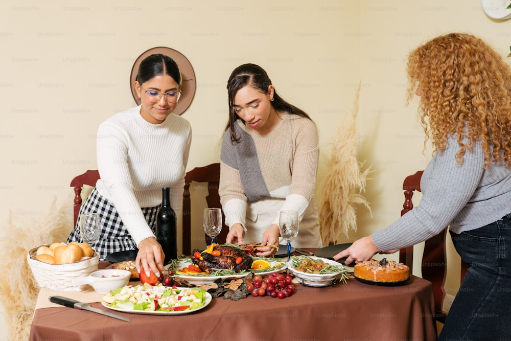 a group of women standing around a table with plates of food