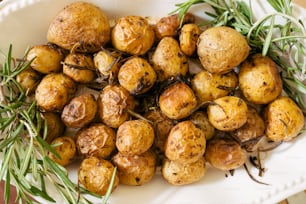 a white plate topped with potatoes and herbs