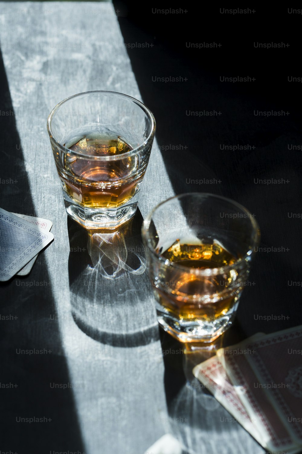 two glasses of whiskey sitting on a table