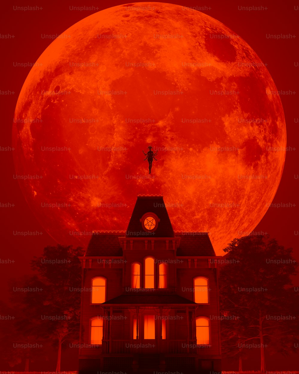 a large red full moon over a house