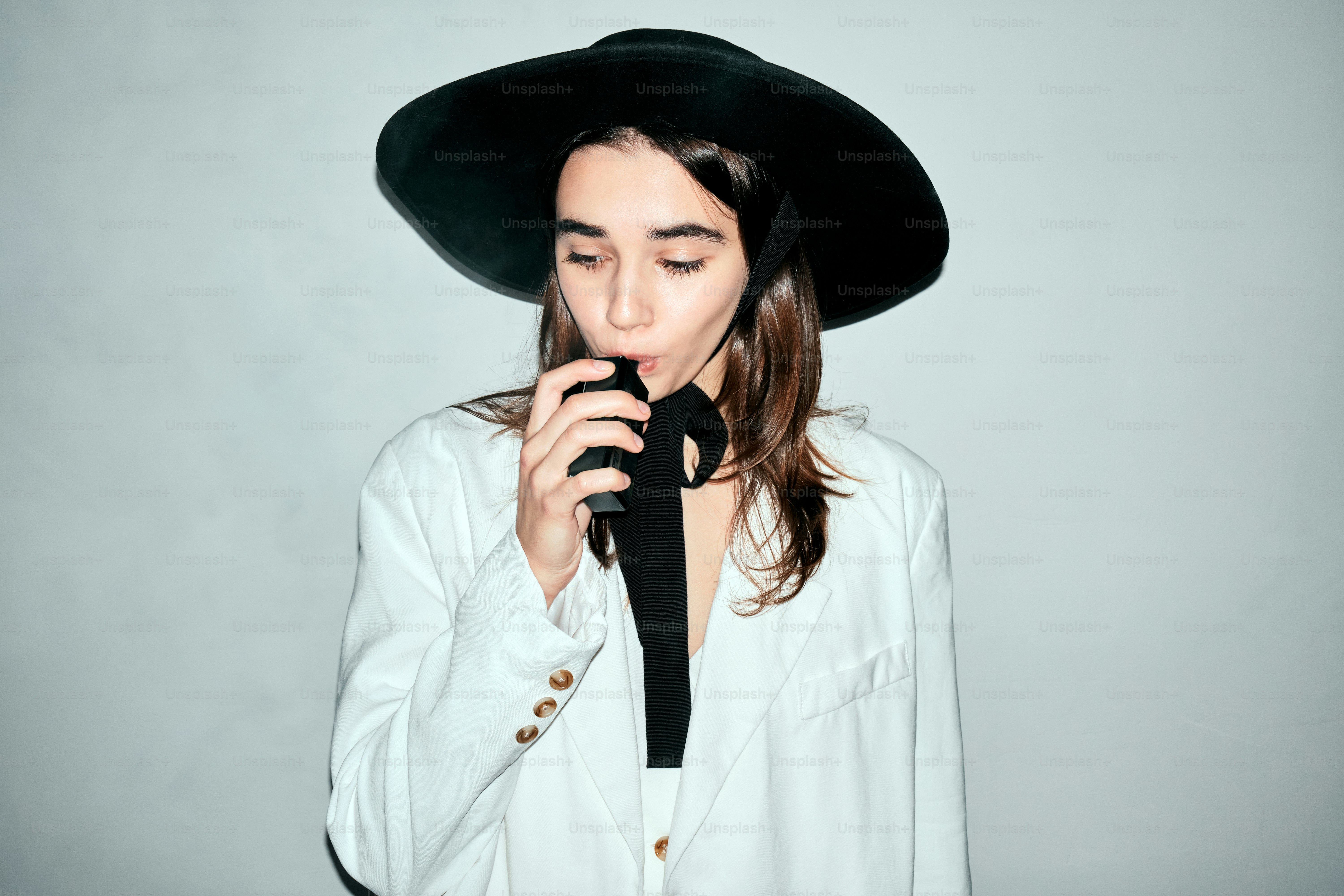 a woman wearing a black hat and a black tie