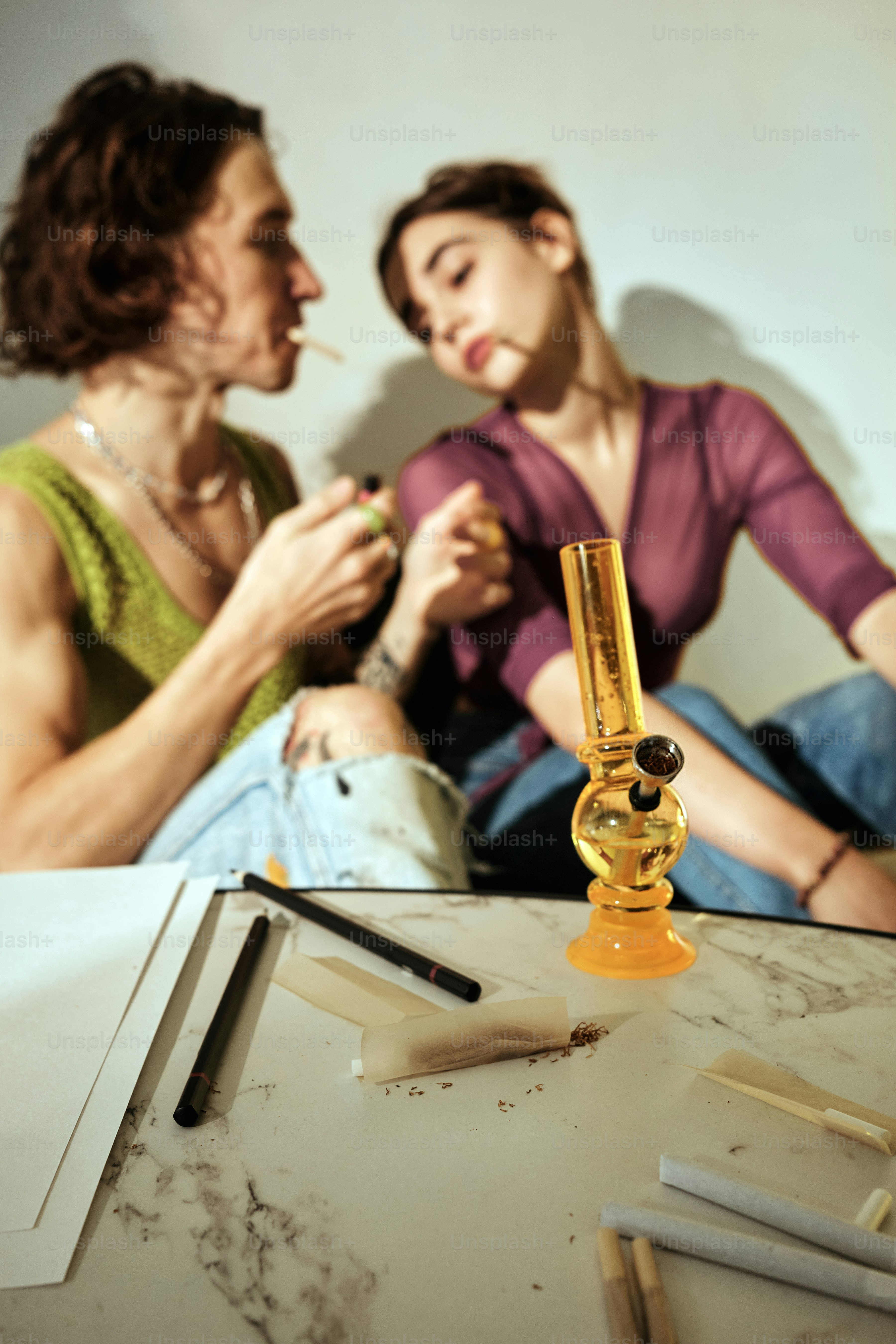 A couple of creative young people smoking a joint in an artist's studio