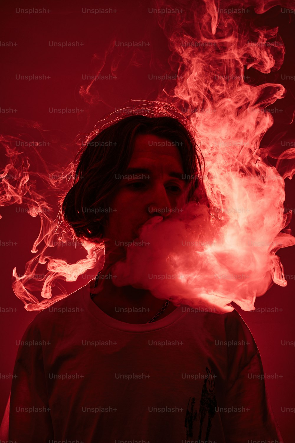 a man smoking a cigarette with red smoke coming out of his mouth