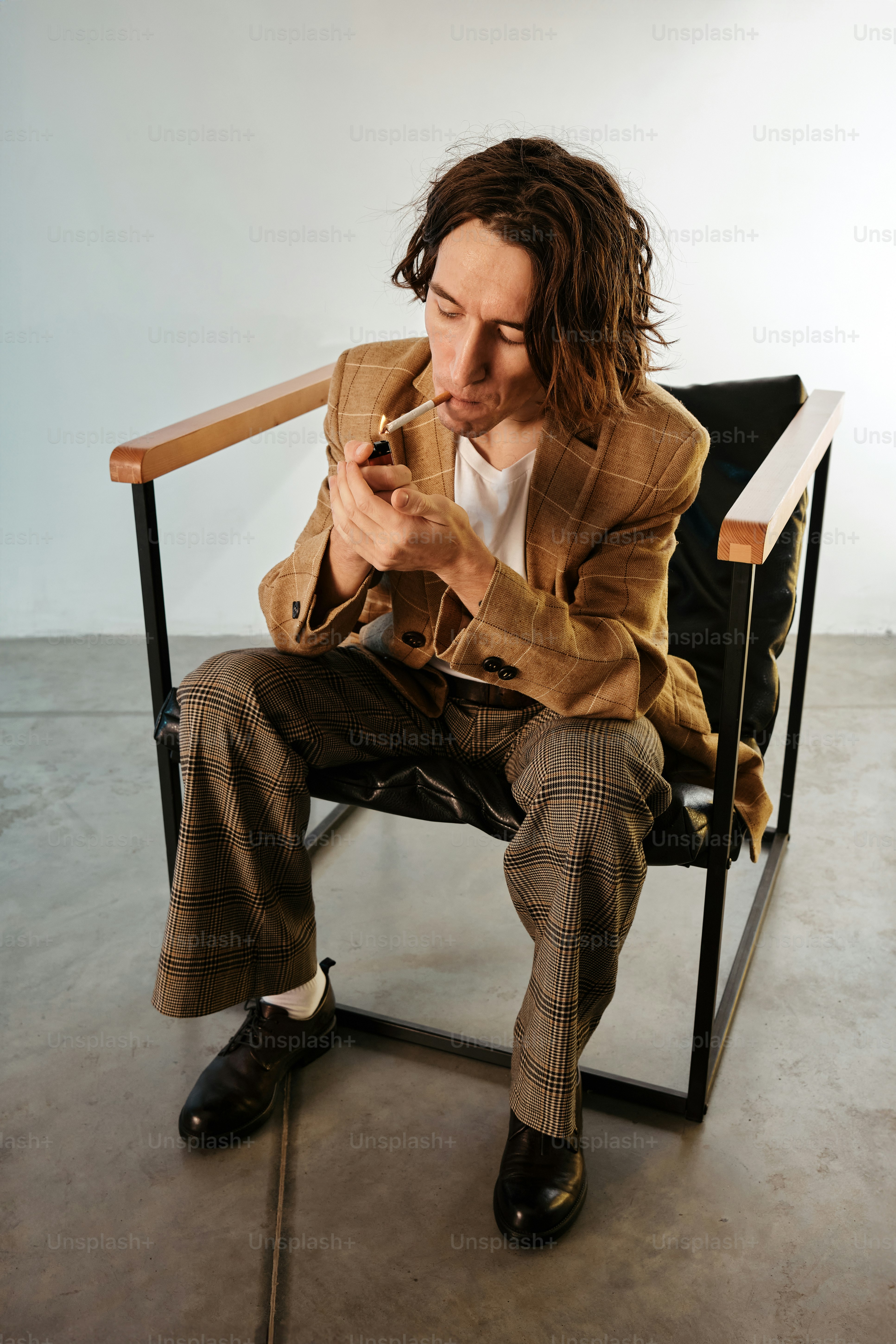 Ein Mann, der auf einem Stuhl sitzt und eine Zigarette raucht