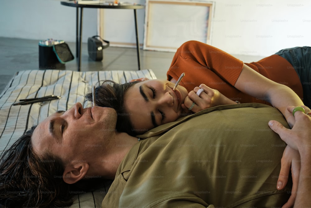 a man laying on a bed next to a woman