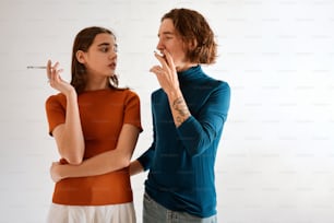 a woman standing next to another woman smoking a cigarette