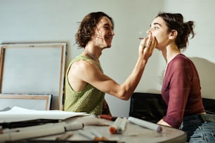 a man and a woman standing in front of a mirror brushing their teeth