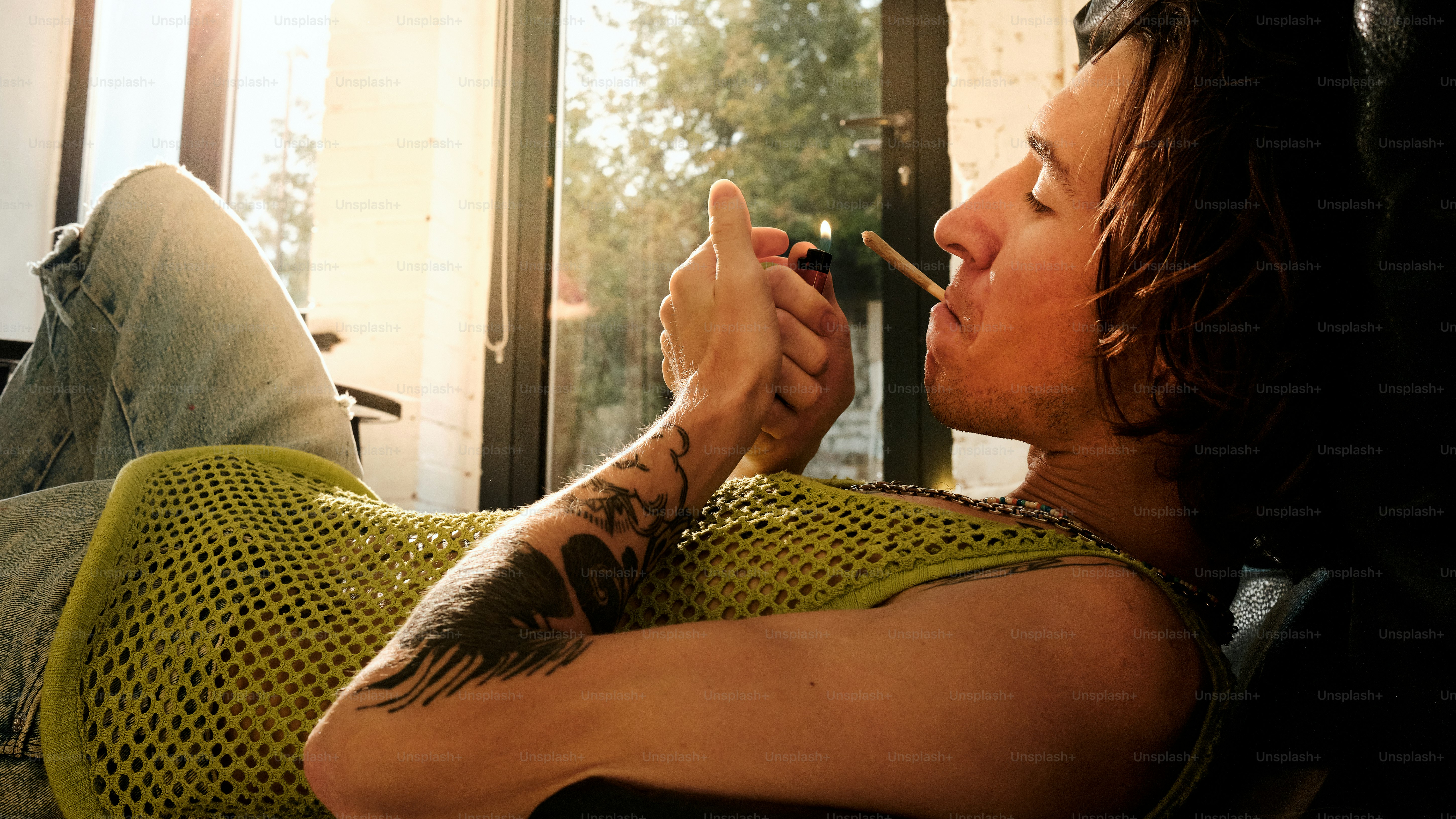 a man smoking a cigarette on a couch