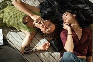a couple of women laying on top of a wooden floor