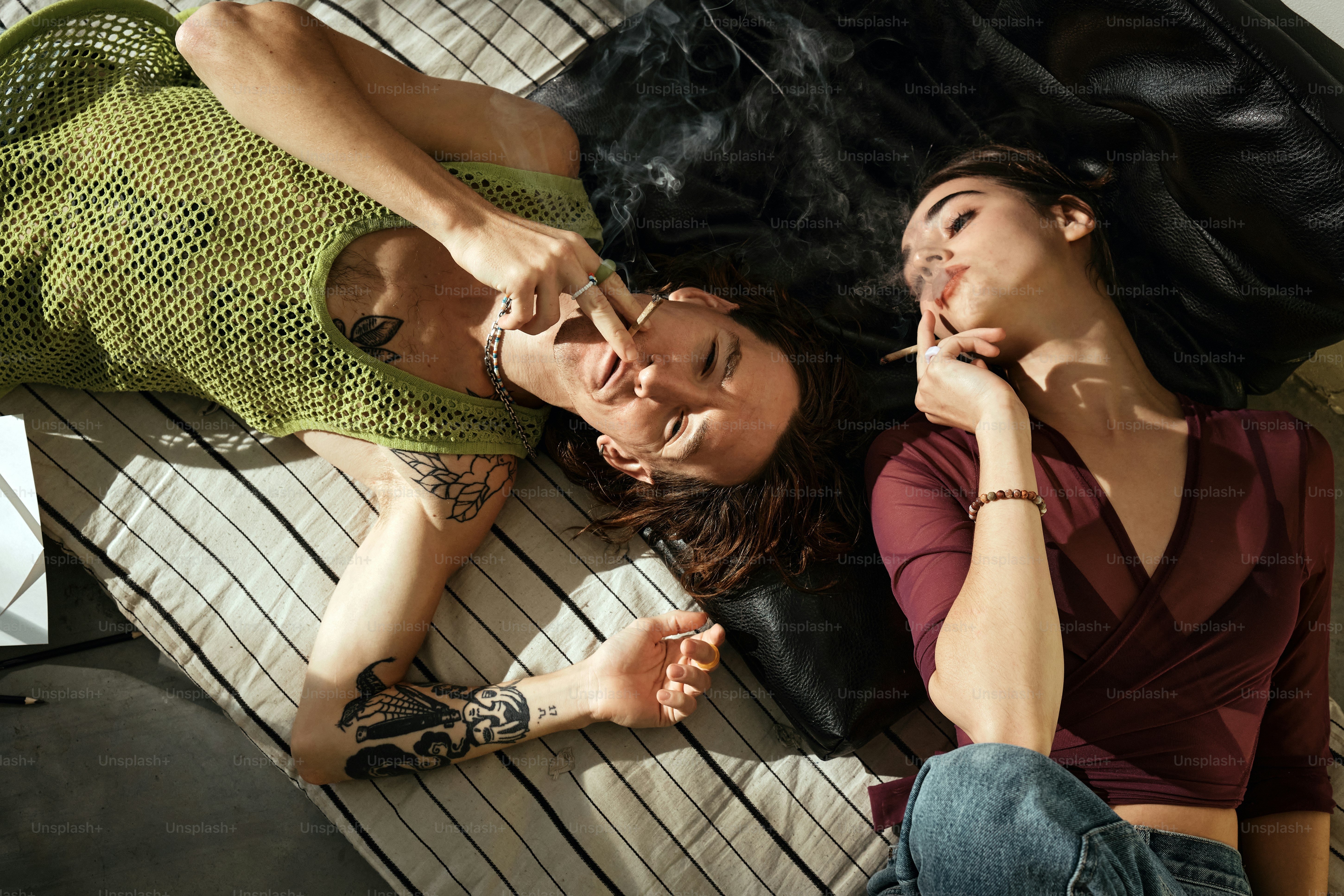 A couple of creative young people smoking a joint in an artist's studio