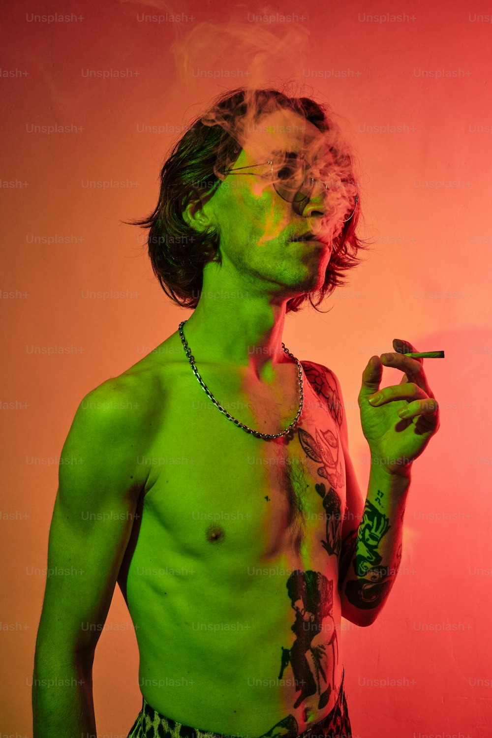 a man smoking a cigarette in a green shirt