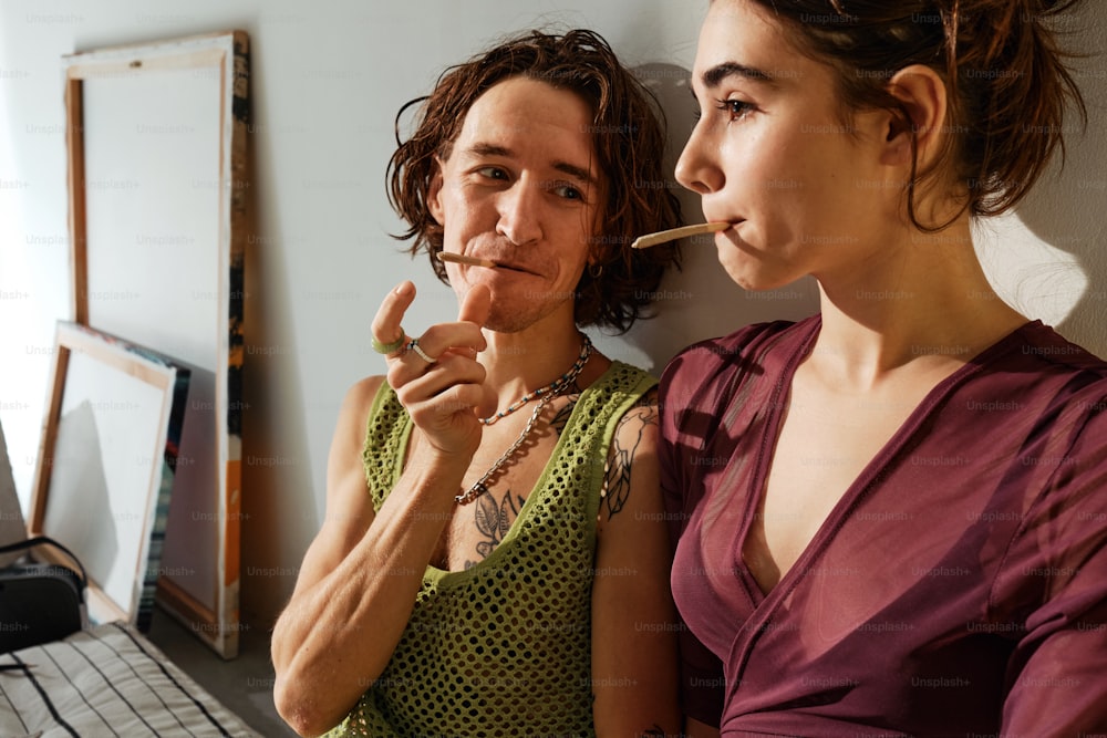 a woman smoking a cigarette next to another woman