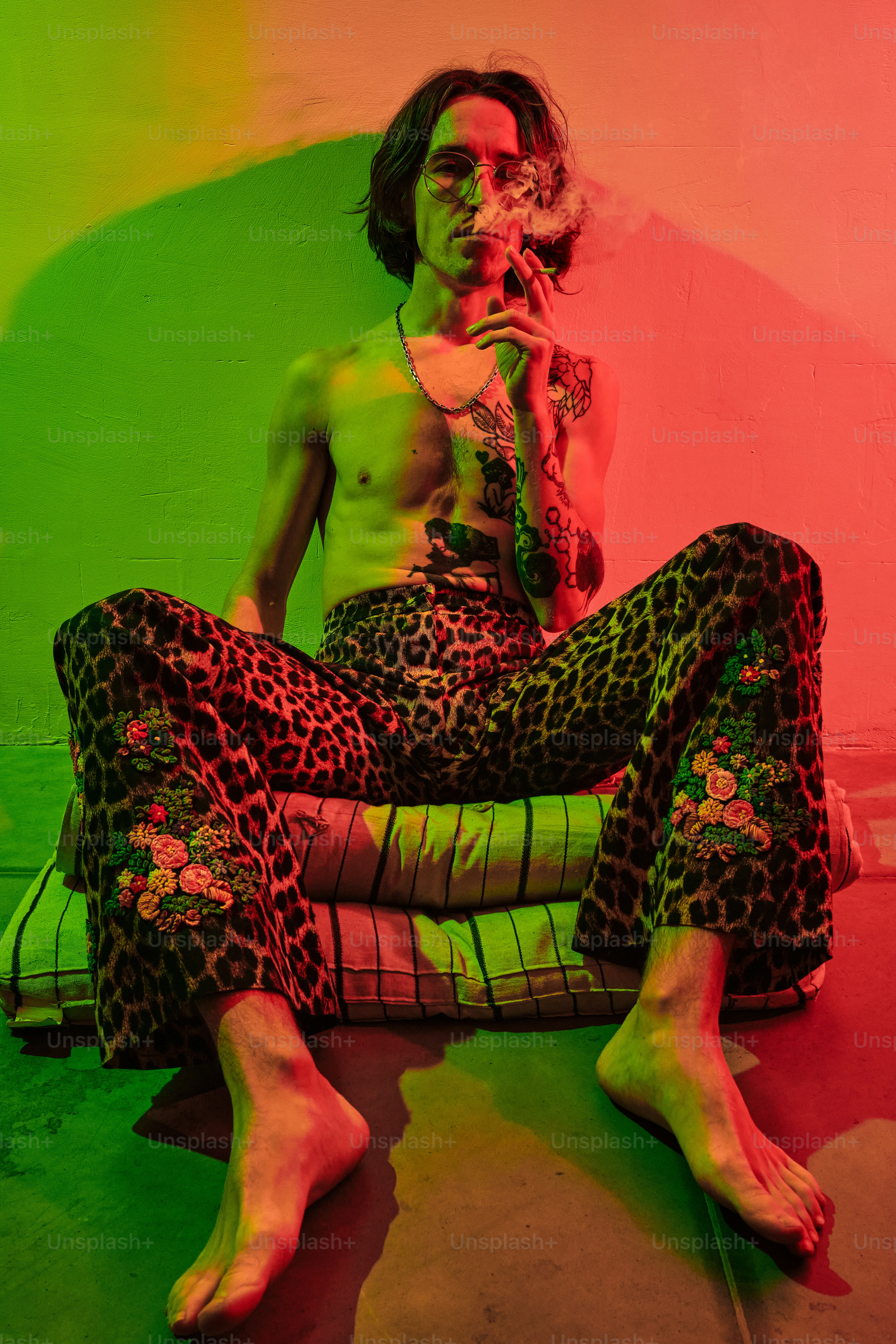 Ein Mann, der auf dem Boden sitzt und eine Zigarette raucht