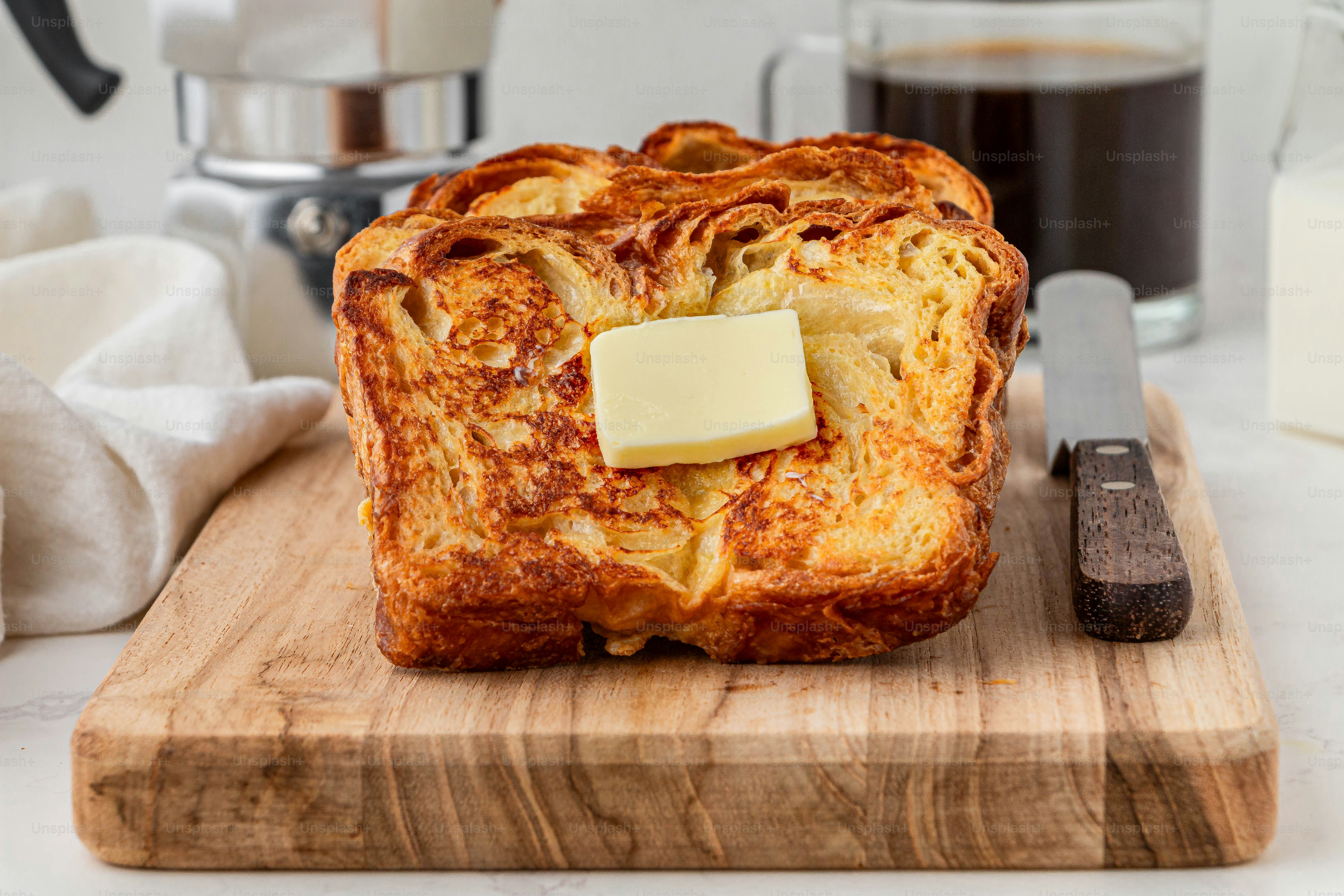 a wooden cutting board topped with a piece of bread