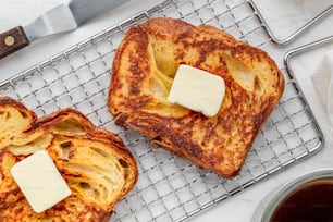 two pieces of french toast with butter on a cooling rack