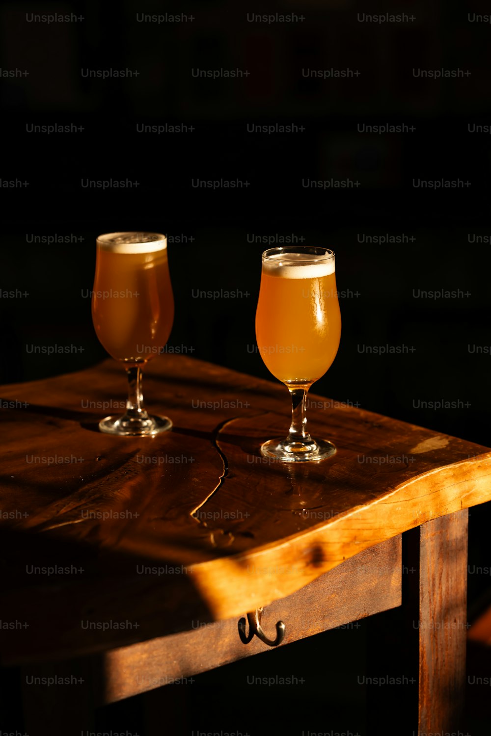 two glasses of beer are sitting on a table