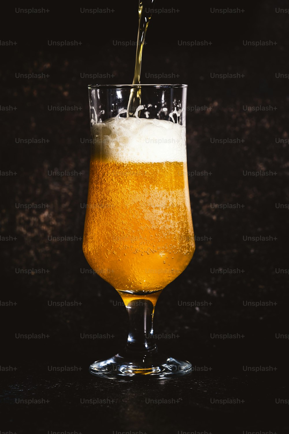 a glass of beer being poured into it
