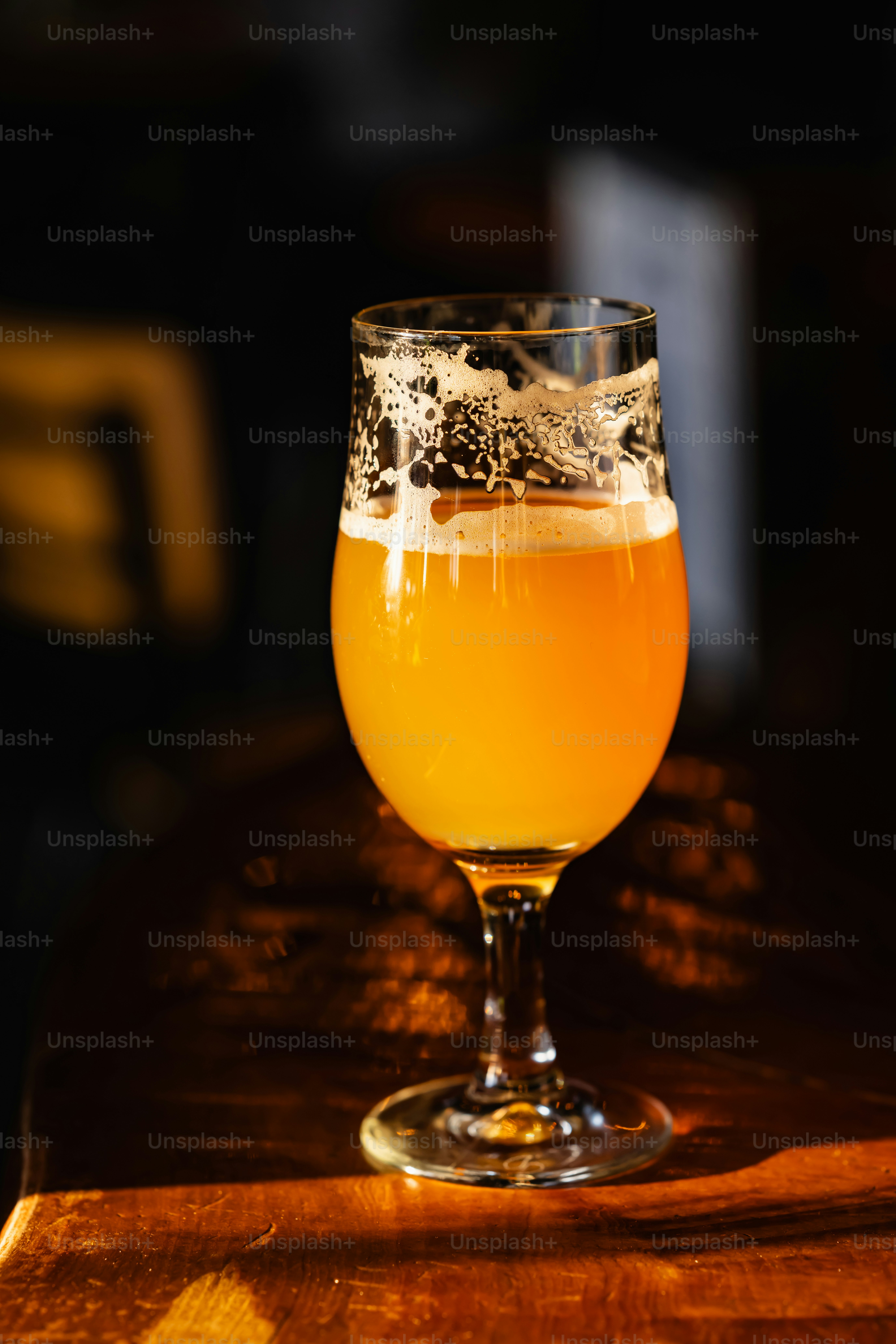 나무 테이블 위에 앉아 있는 맥주 한 잔