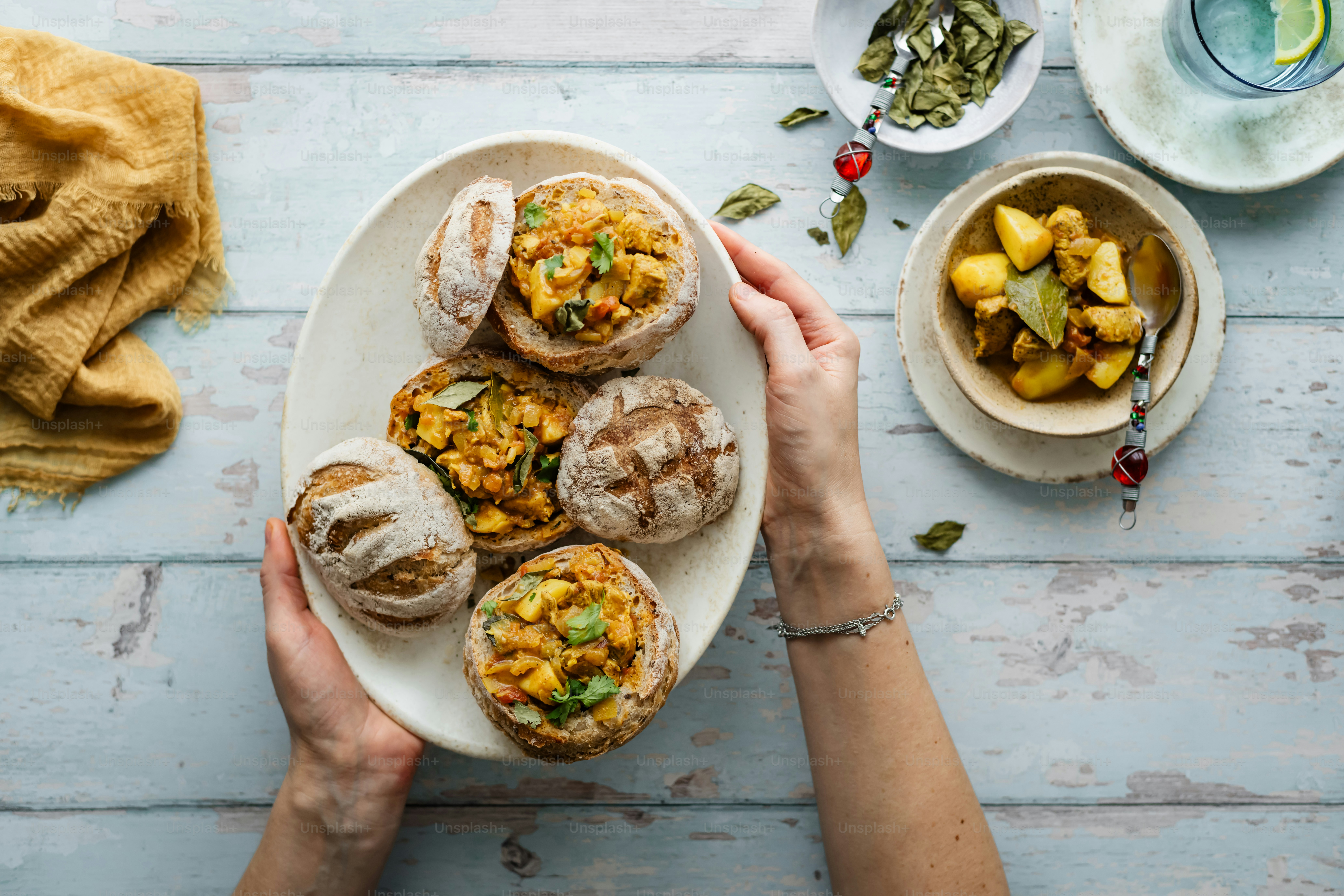 a person holding a plate of food on a table