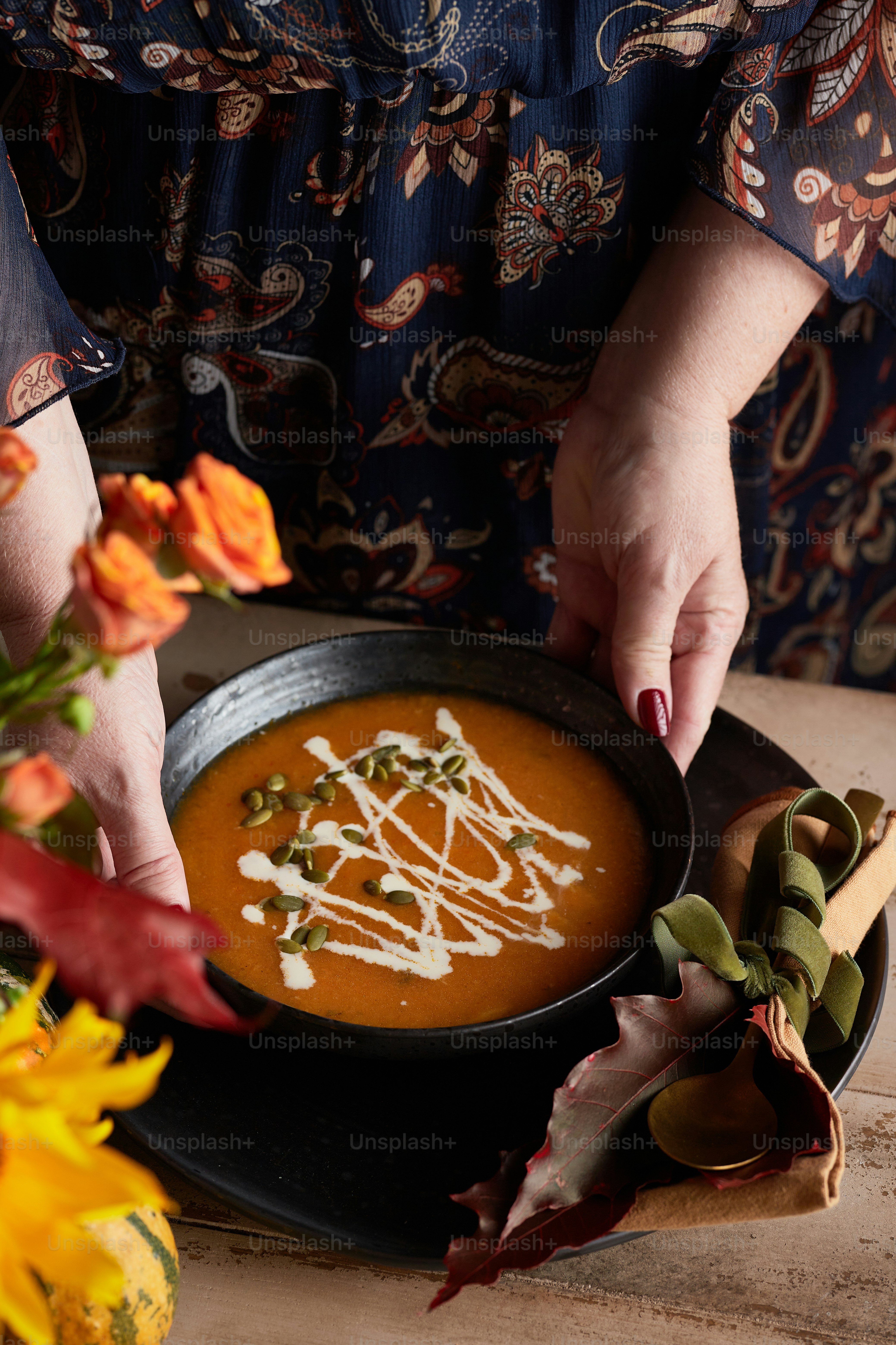 Eine Frau taucht eine Soße in eine Schüssel Suppe