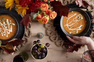 a table topped with bowls of soup and plates of fruit