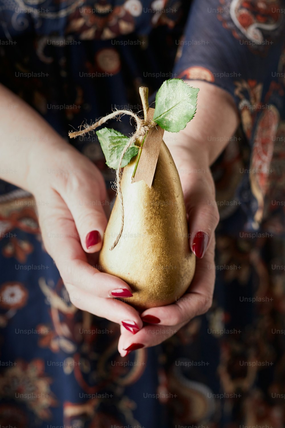 a woman holding a pear in her hands