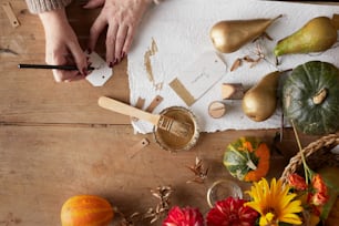 a table with flowers, gourds, and paper on it