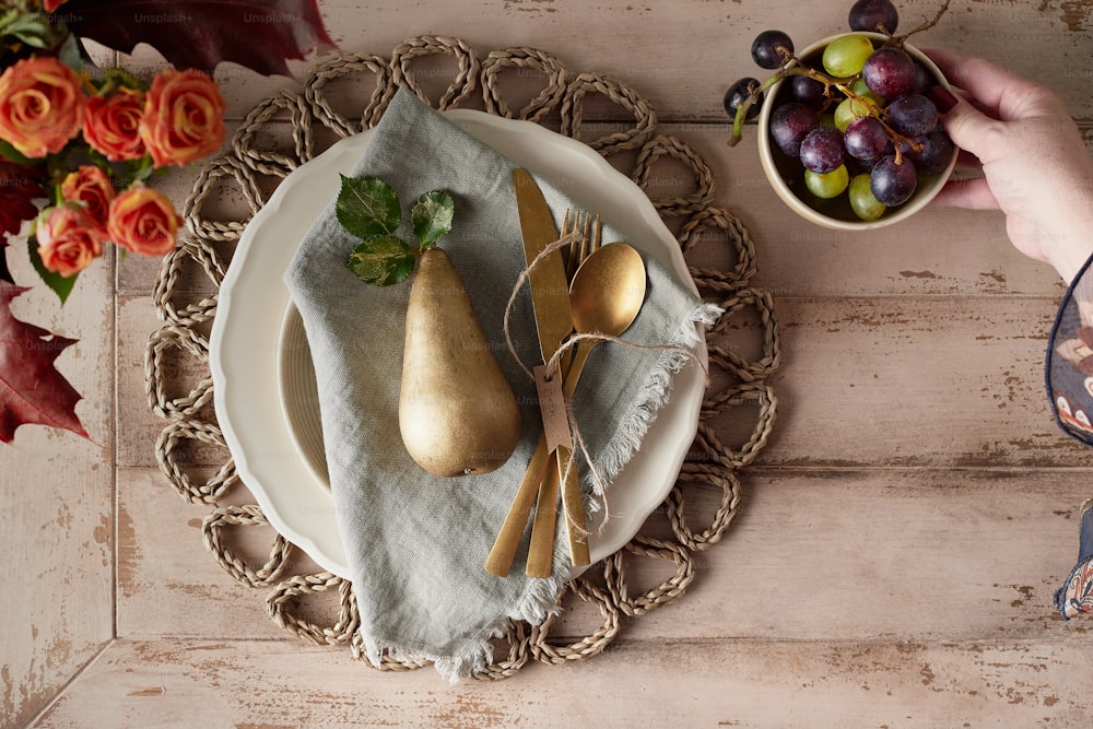 um prato coberto com peras ao lado de uma tigela de uvas