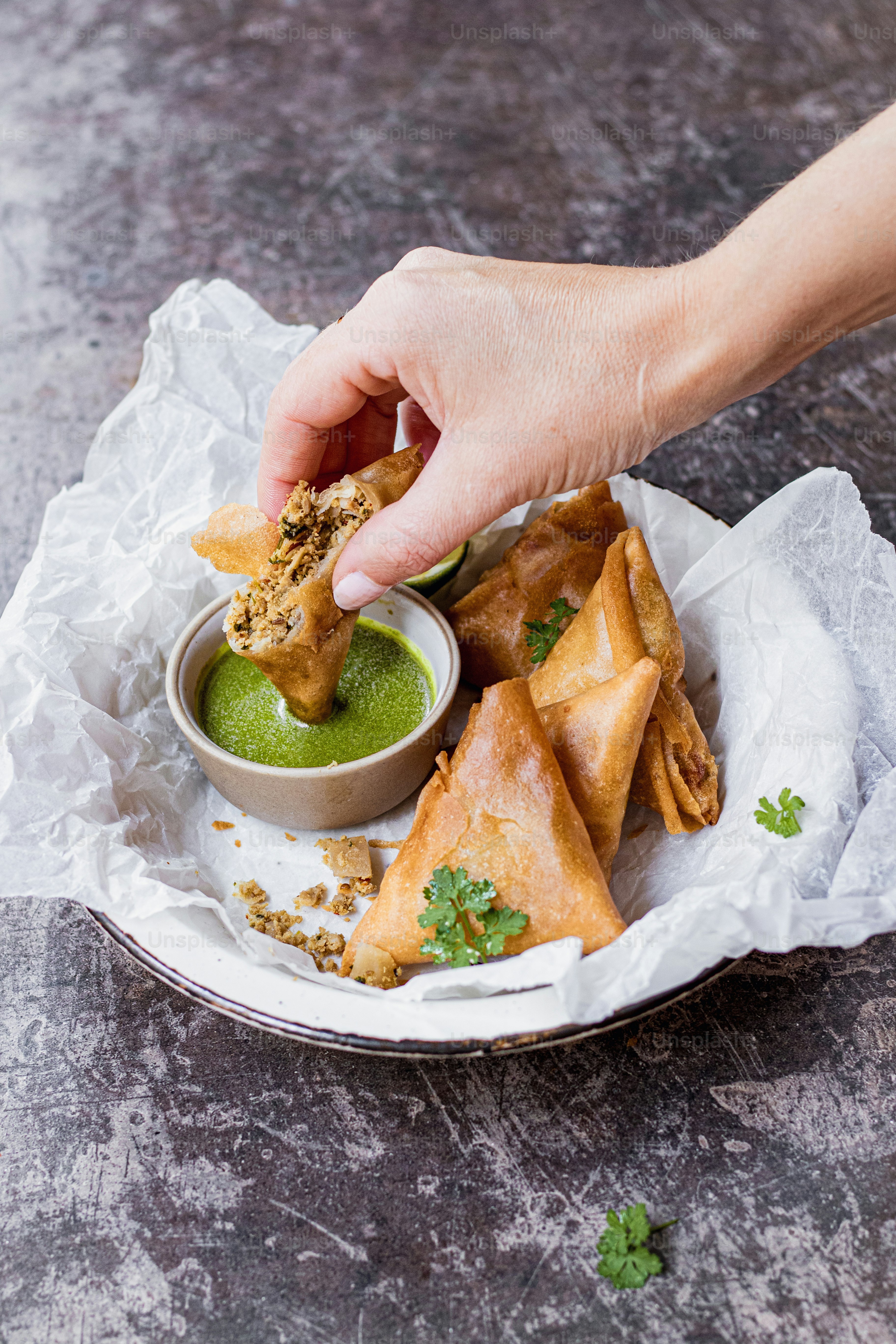 a person dipping some food into a bowl
