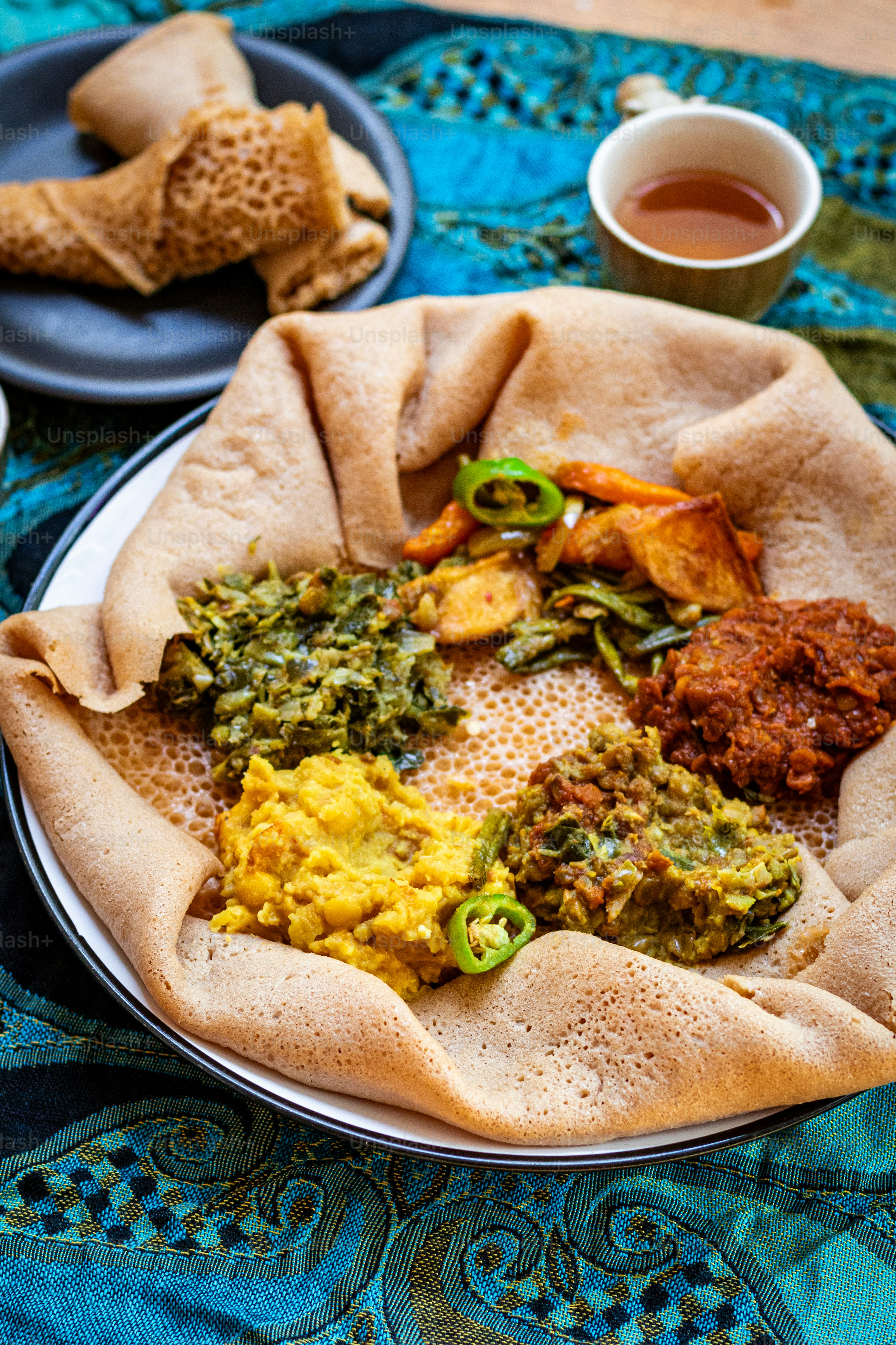 a plate of food on a table next to a cup of tea
