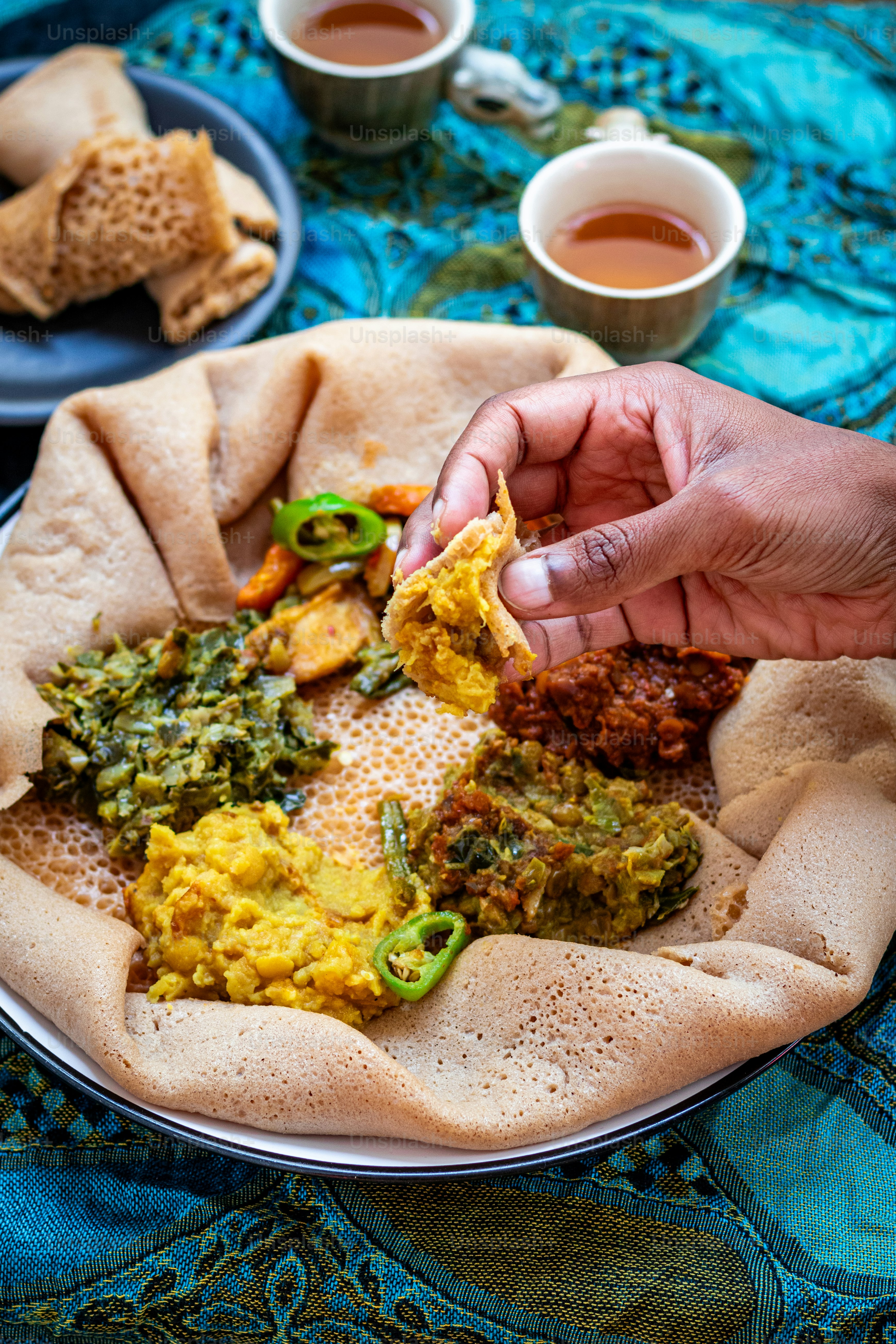 a plate of food on a table with cups of tea
