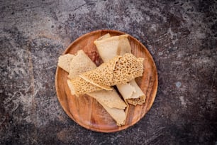 a wooden plate topped with crackers on top of a table