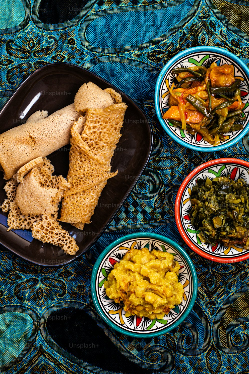 a table topped with plates of food on top of a blue table cloth