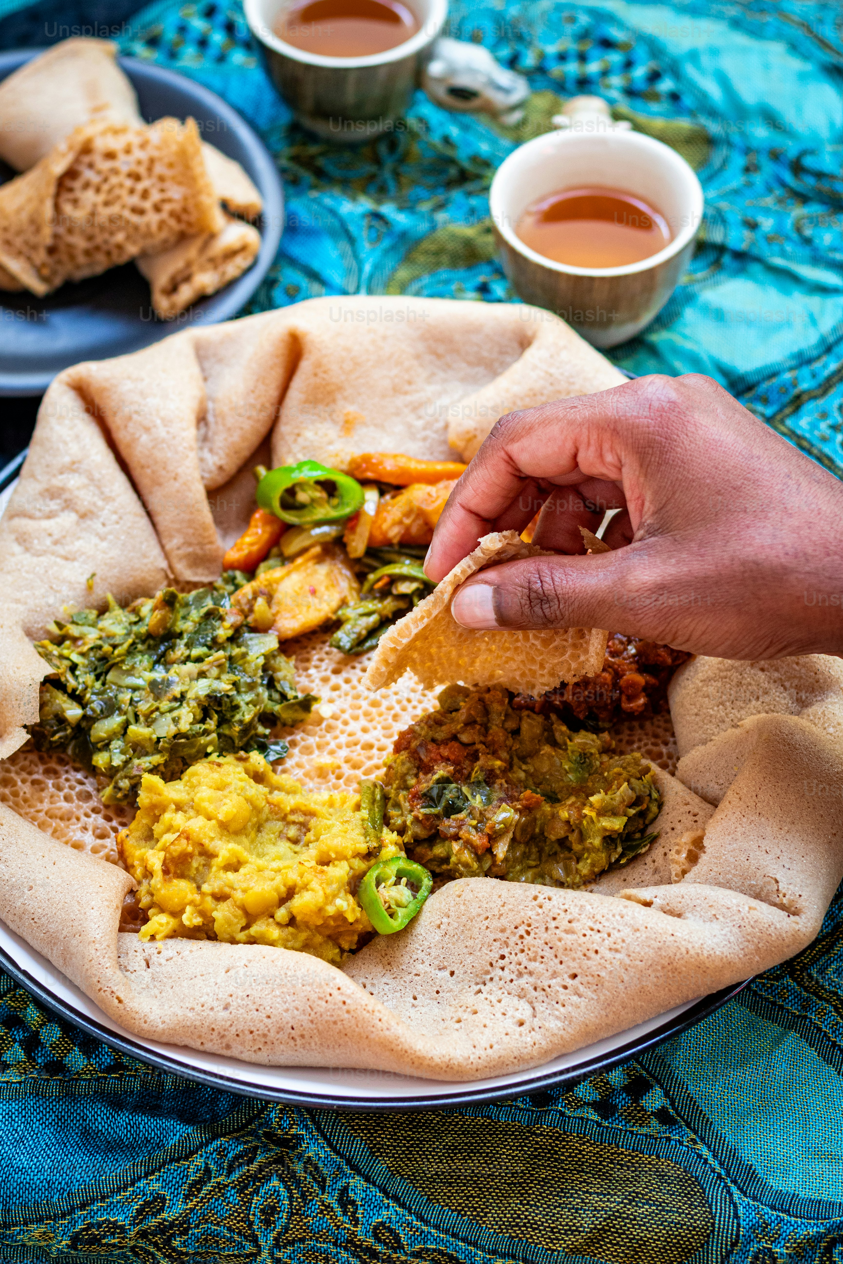 a plate of food on a table with cups of tea