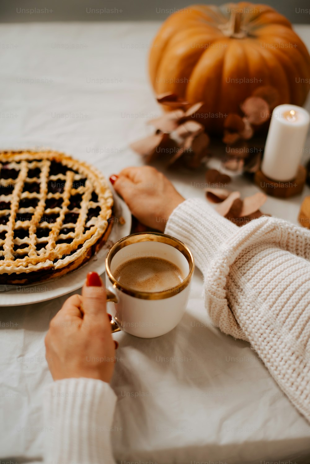 a woman holding a cup of coffee next to a pie