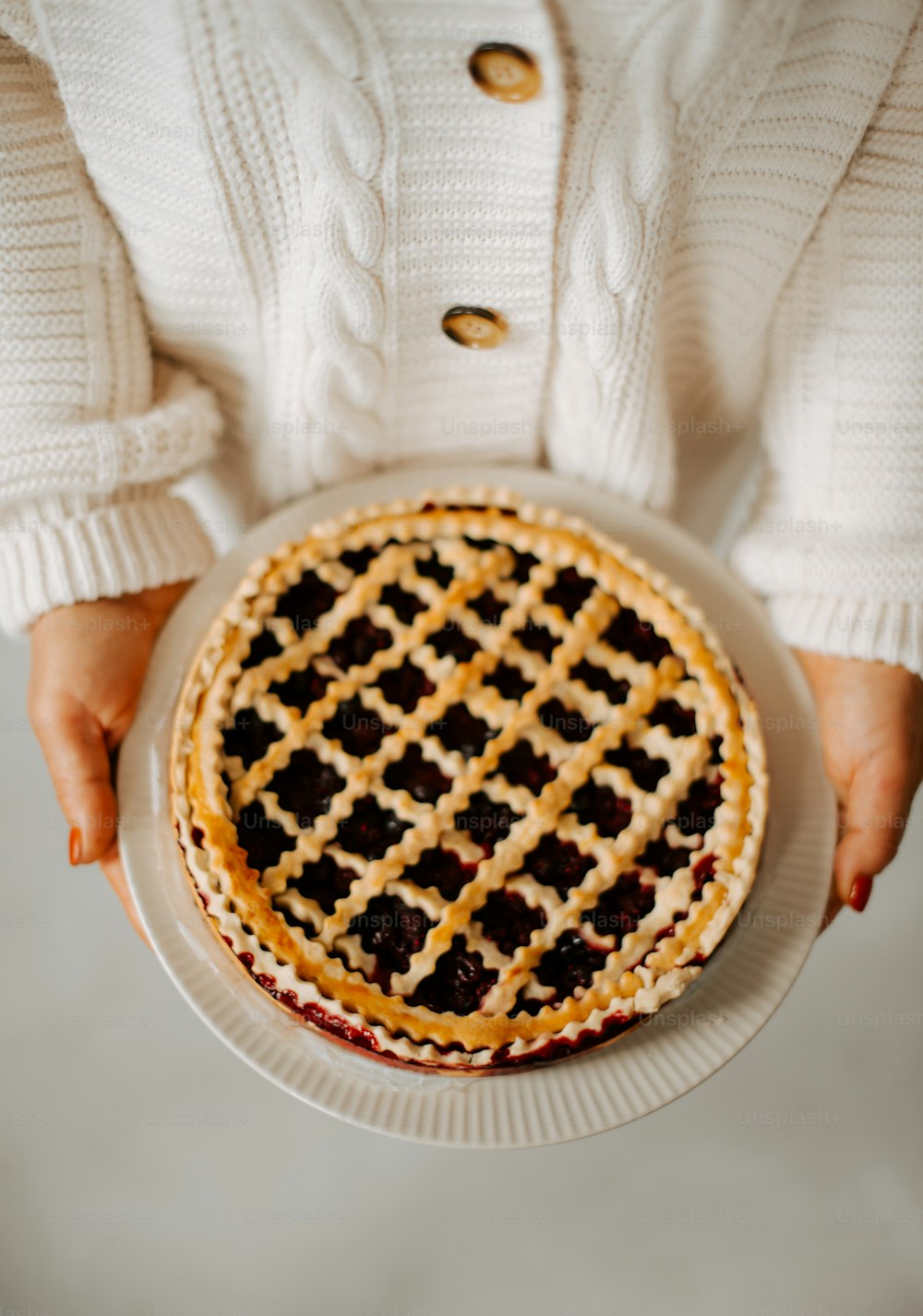 a person holding a pie on a plate