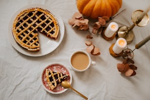 a table topped with a plate of pie next to a cup of coffee