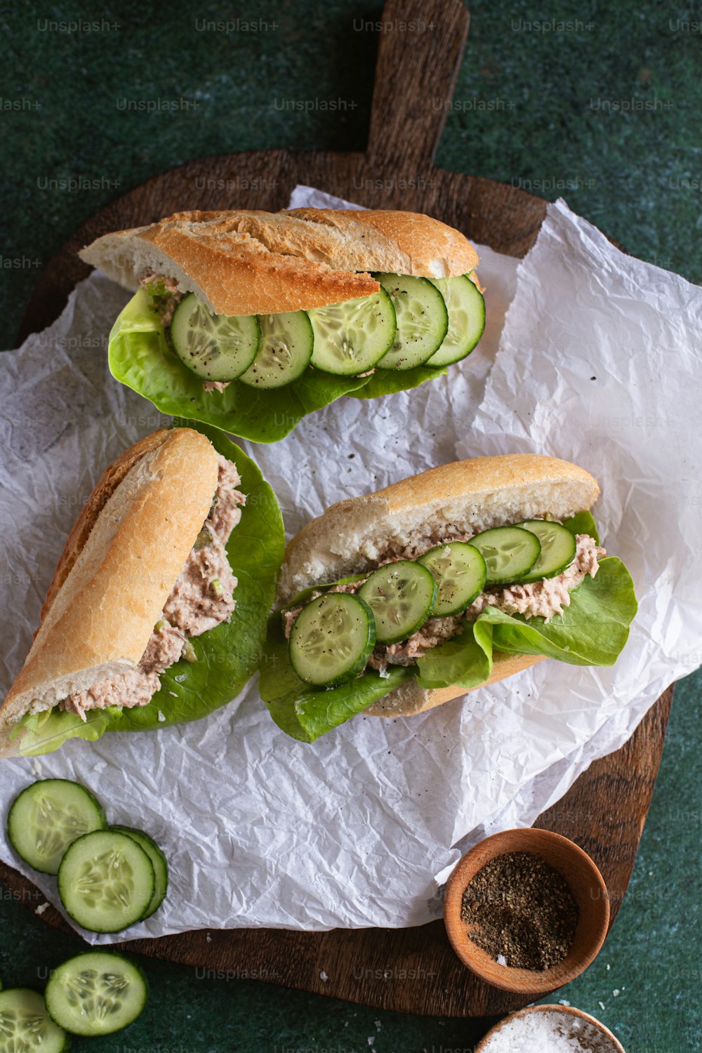 a couple of sandwiches sitting on top of a wooden cutting board