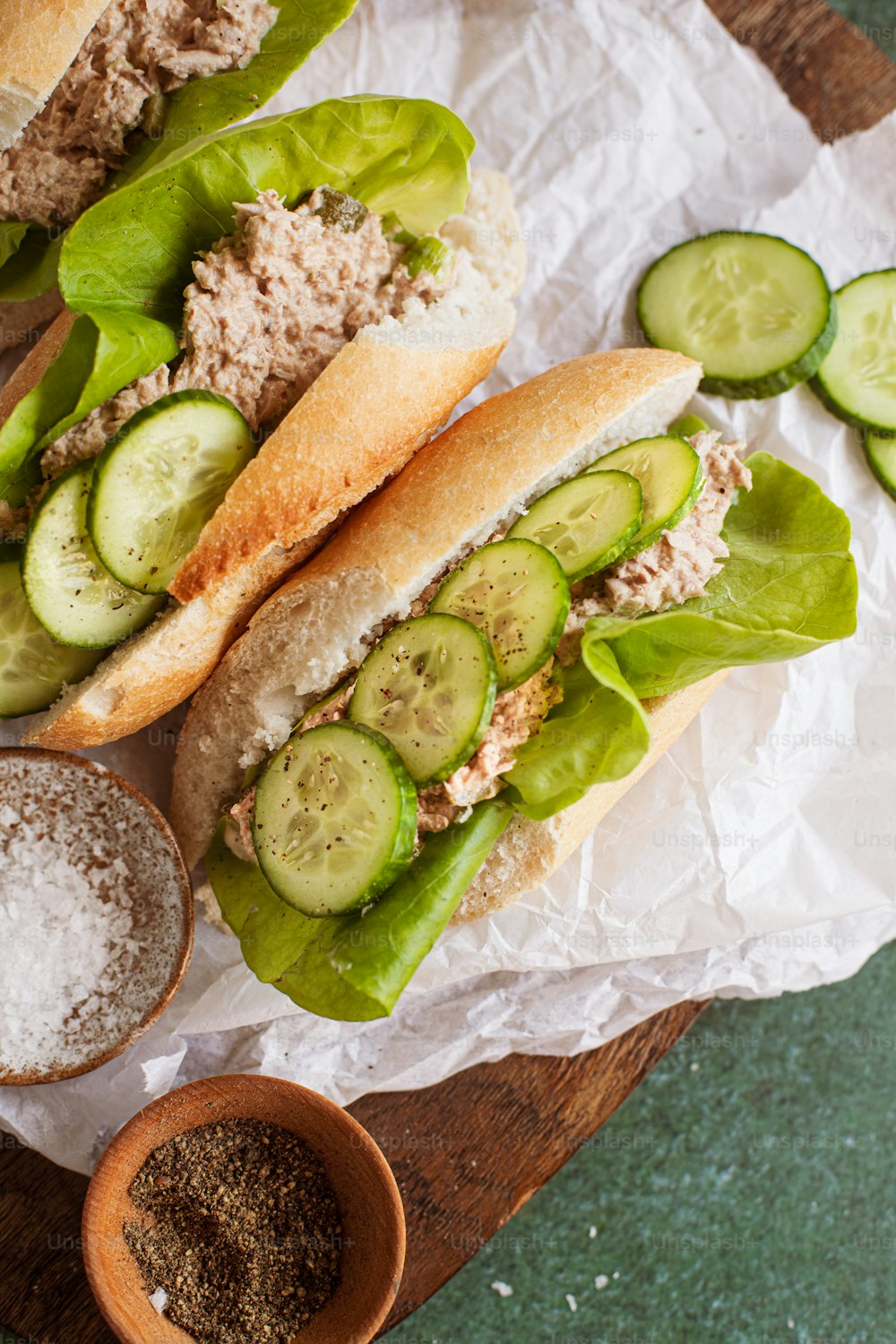 a couple of sandwiches sitting on top of a wooden cutting board