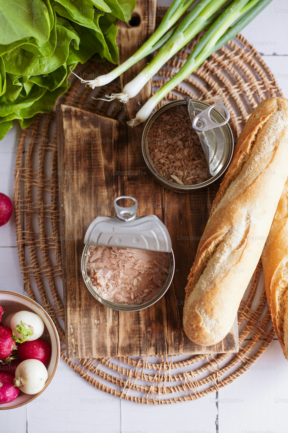 pão, rabanetes e outros ingredientes em uma bandeja de madeira
