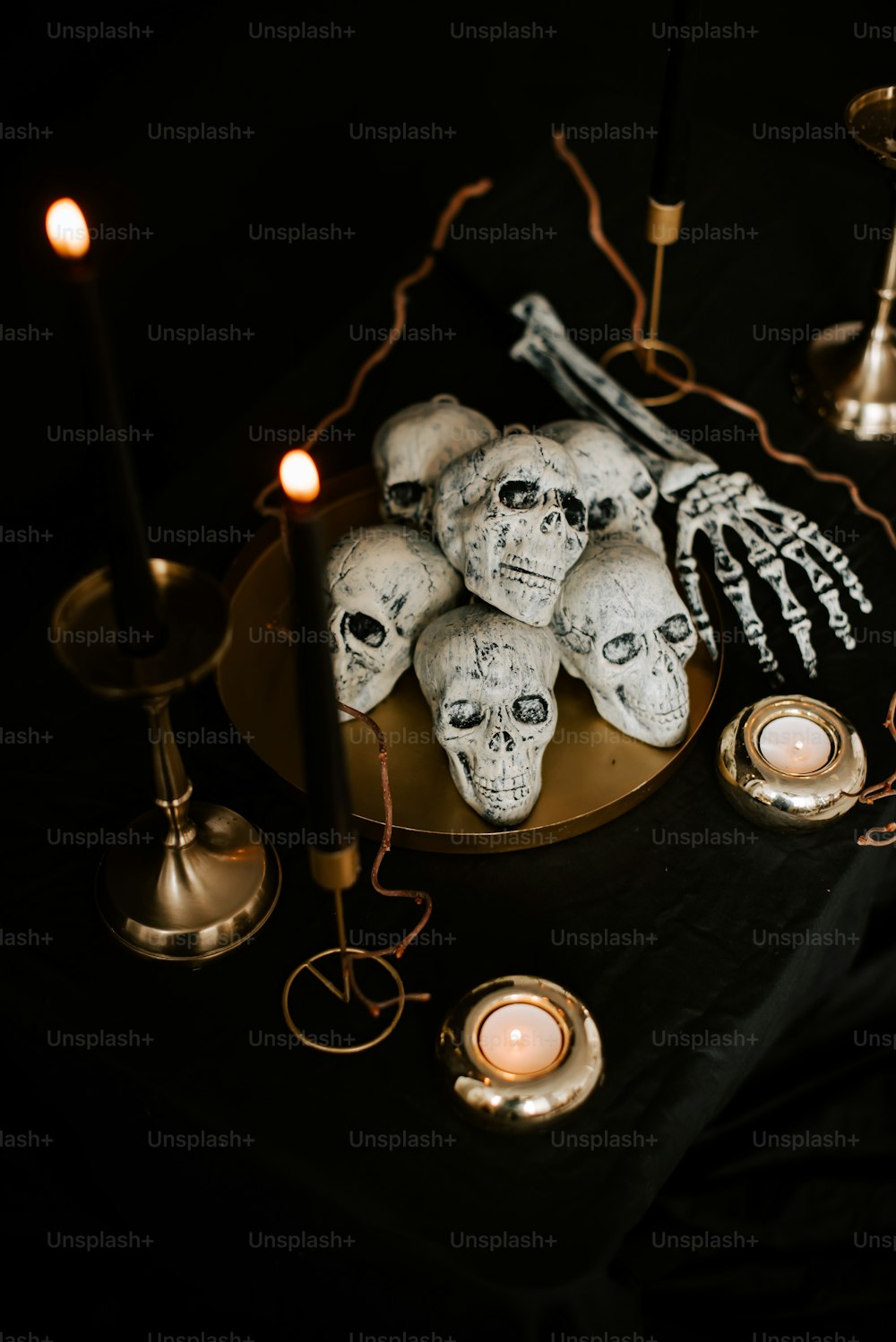 une table avec des bougies et des crânes dessus