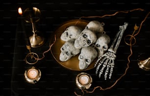a table topped with a plate of skulls and candles
